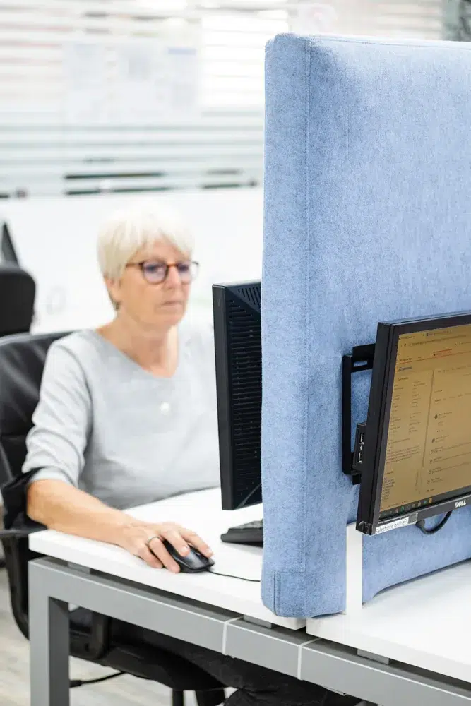 Akoestische scheidingswand naast een werkplek in een kantoor
